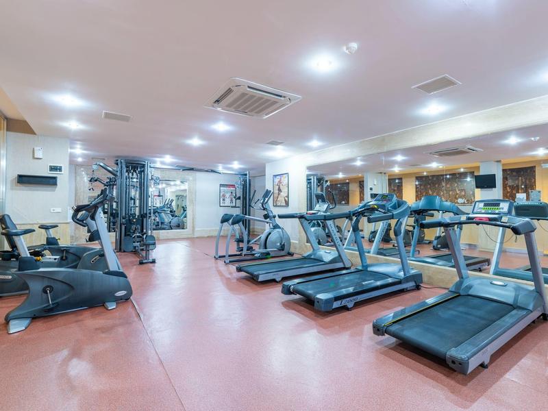 Ampia palestra con tapis roulant e attrezzi per la forza, zona luminosa e ben attrezzata.