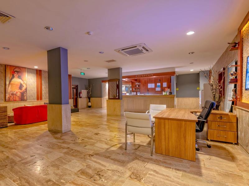 Ampia hall dell'hotel con reception, zone salotto e arte contemporanea alle pareti.