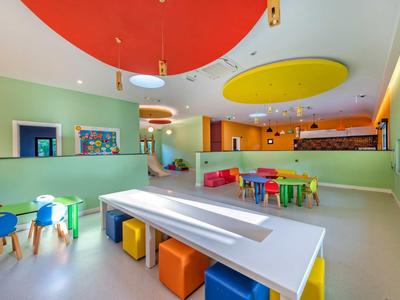 Bright, colorful playroom with small tables and chairs designed for children.