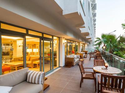 Large terrace with chairs and tables beside a hotel restaurant.