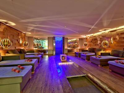 Relaxing spa room with wooden paneling, cozy loungers, and ambient lighting.