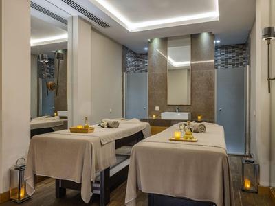 Sala de masajes moderna con dos camillas cómodas, luz tenue y ambiente relajante.