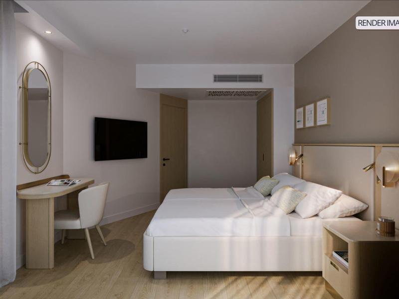 Modern hotel room with double bed, flat-screen TV, and desk with chair.