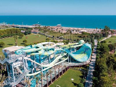 Parco acquatico con grandi scivoli d'acqua accanto a un hotel sul mare.
