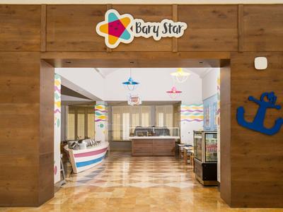 Ingresso in un'area reception colorata con pareti in legno e accenti marittimi.