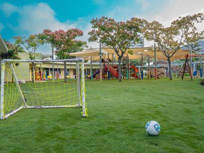 Parco giochi per bambini con piccolo goal di calcio e pallone su prato sintetico verde
