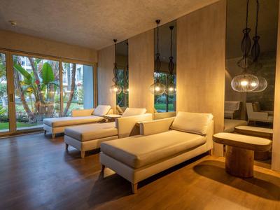 Soggiorno moderno con divani beige, grandi finestre e pavimento in legno caldo.