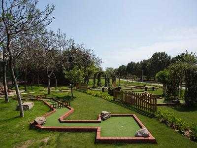 Campo da minigolf con piste verdi e cespugli in una giornata di sole