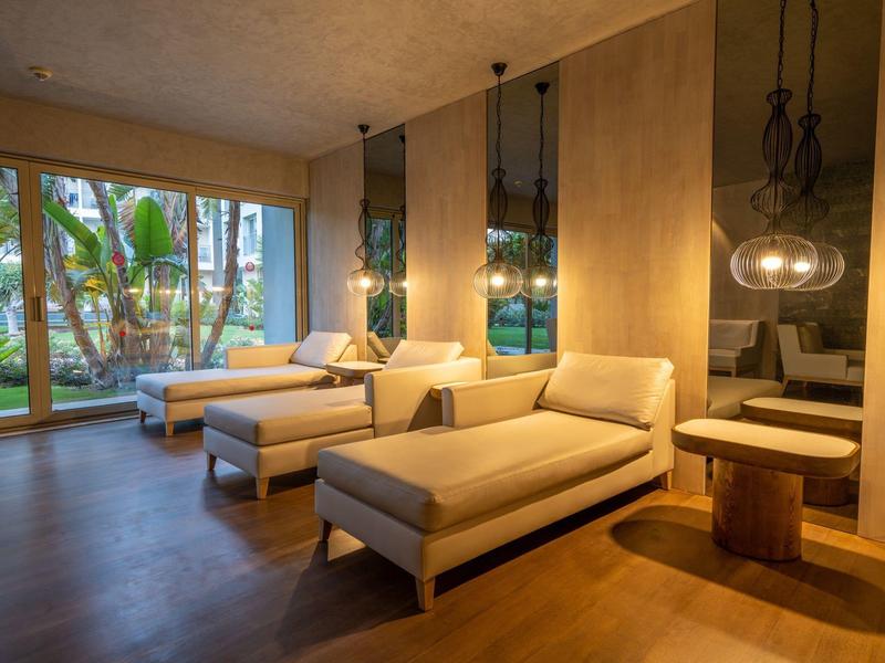 Soggiorno moderno con divani beige, grandi finestre e pavimento in legno caldo.