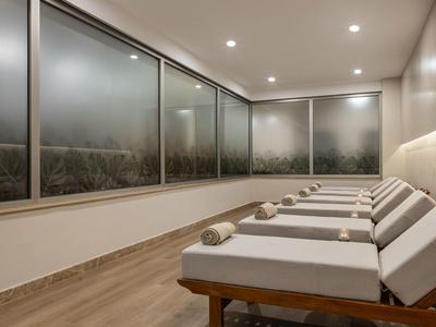 Ruhebereich mit Liegestühlen und großen Fenstern in einem modernen Interieur.