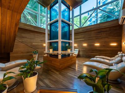 Gemütlicher Wellnessbereich mit bequemen Liegen, Pflanzen und großflächigen Fenstern