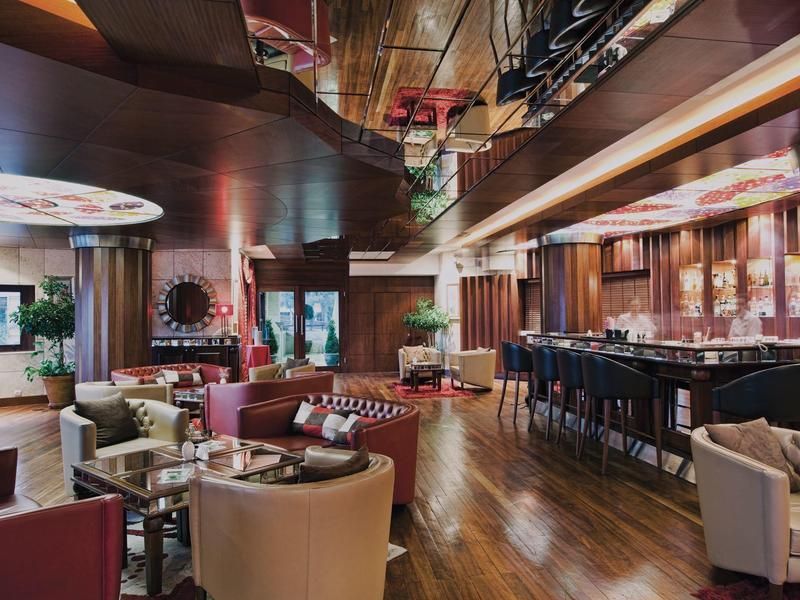 Modern eingerichtete Hotelbar mit Sitzgruppen und Holzboden in warmen Farbtönen.