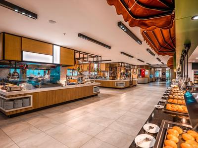 Large buffet with diverse offerings in a modern, bright hotel dining area.