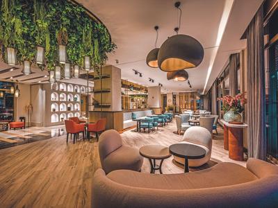 Modern hotel lobby with cozy seating areas and warm lighting.