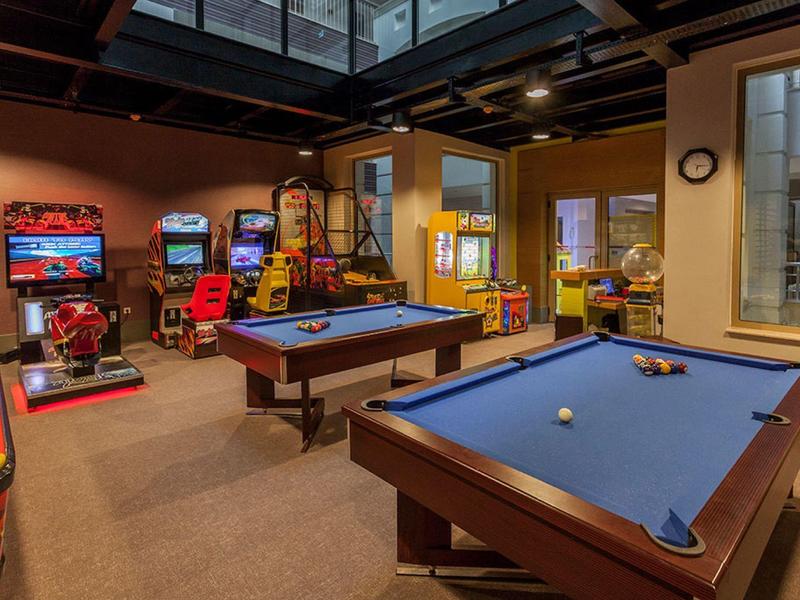 Area ricreativa con tavoli da biliardo e giochi arcade in un hotel