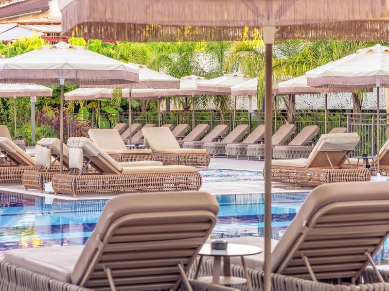 Lettini comodi e ombrelloni intorno a una piscina esterna di un hotel.