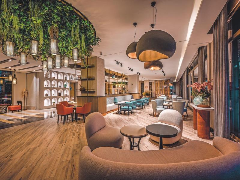 Ristorante d'hotel moderno con aree salotto accoglienti, luci sospese e pavimento in legno