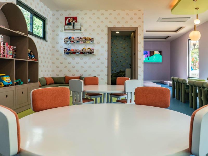 Sala de desayuno moderna con sillas y mesas coloridas en un hotel.