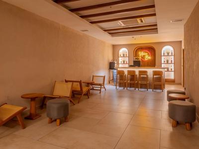 Bright room with wooden chairs, coffee tables, and a bar along the wall