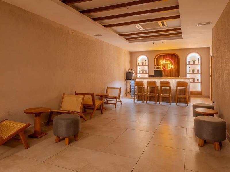 Bright room with wooden chairs, coffee tables, and a bar along the wall