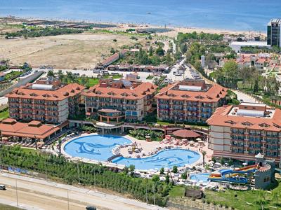 Grande resort con più edifici e una grande piscina in posizione soleggiata.