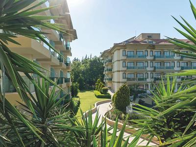 Due edifici alberghieri a più piani con giardino verde sotto il sole