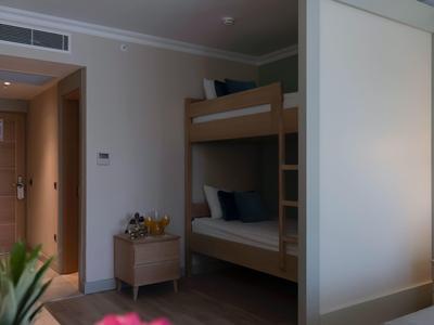 Piccola stanza d'hotel con letto a castello, comodino e arredo minimalista.