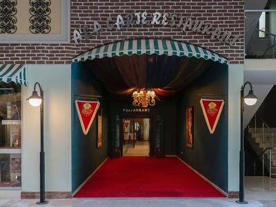 Ingresso con tappeto rosso e gagliardetti in un hotel o locale elegante.