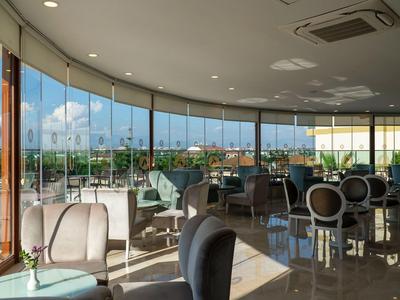 Ruime hotel-lounges met panoramische ramen en stijlvolle zitplaatsen, heldere daglichtsfeer.