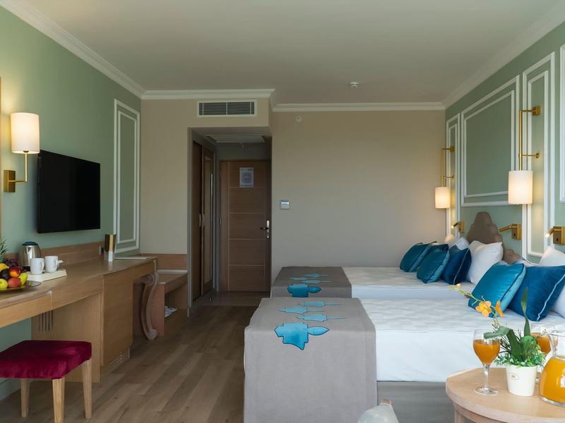 Camera d'hotel moderna con due letti e tavolino con bevande.