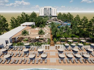 Terraza del hotel con varias tumbonas y sombrillas junto a una piscina rodeada de árboles.