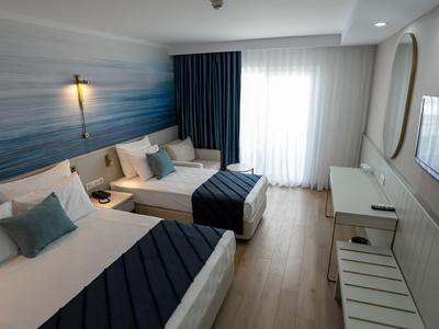 Chambre d'hôtel moderne avec deux lits, bureau et télévision, design lumineux et cosy.