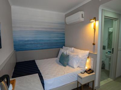 Chambre d'hôtel confortable avec lit queen-size, climatisation et salle de bain moderne.