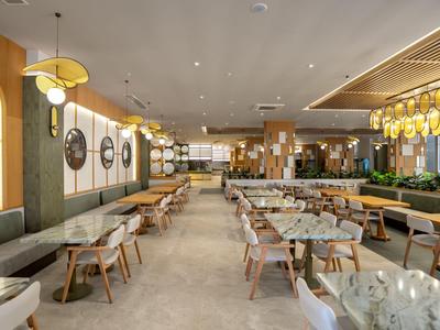 Un restaurant moderne et lumineux avec des tables, des chaises et des miroirs muraux décoratifs.