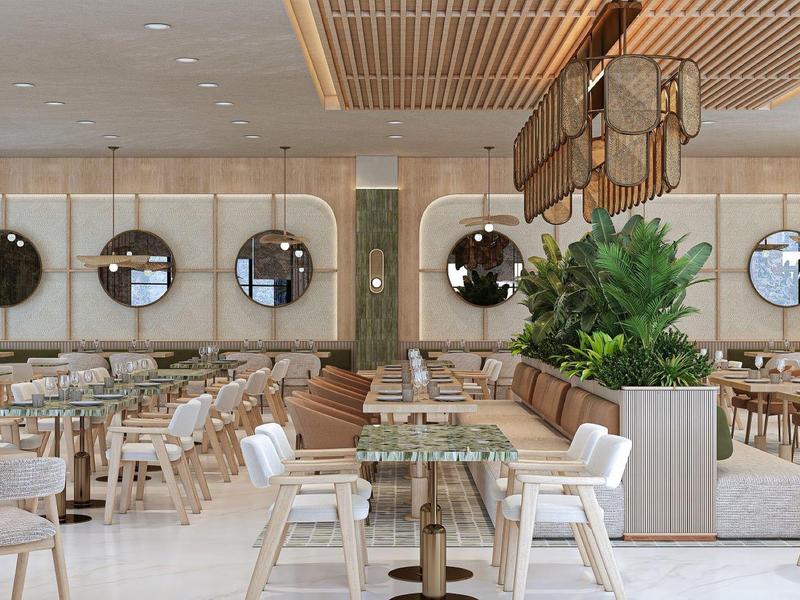 Restaurante moderno y luminoso con espejos redondos en la pared y plantas decorativas.