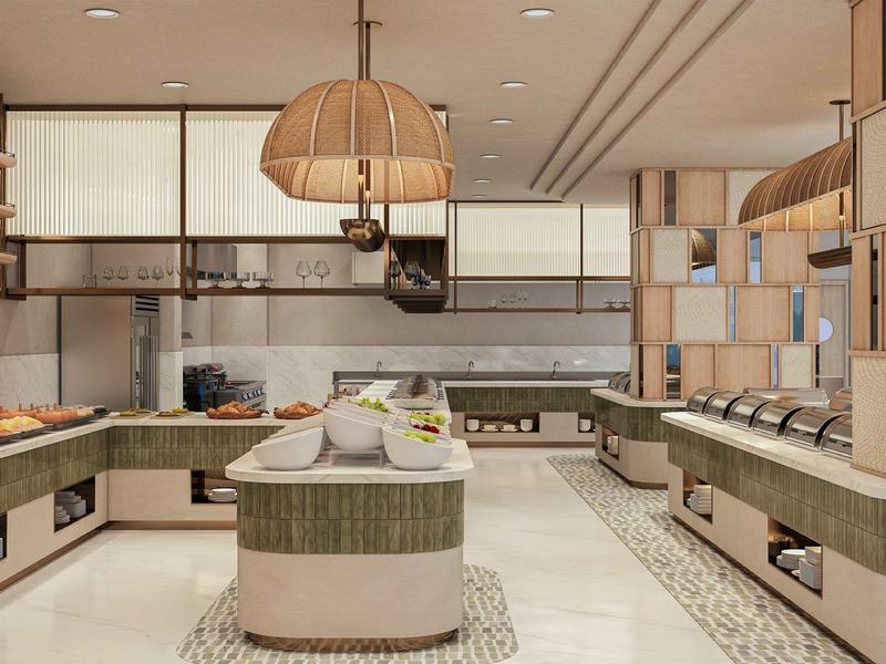 Área de cocina moderna en un hotel con isla y electrodomésticos integrados.