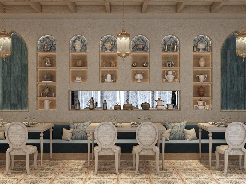 Sala elegante de hotel con sillas claras, estanterías incorporadas y candelabro de hierro forjado.