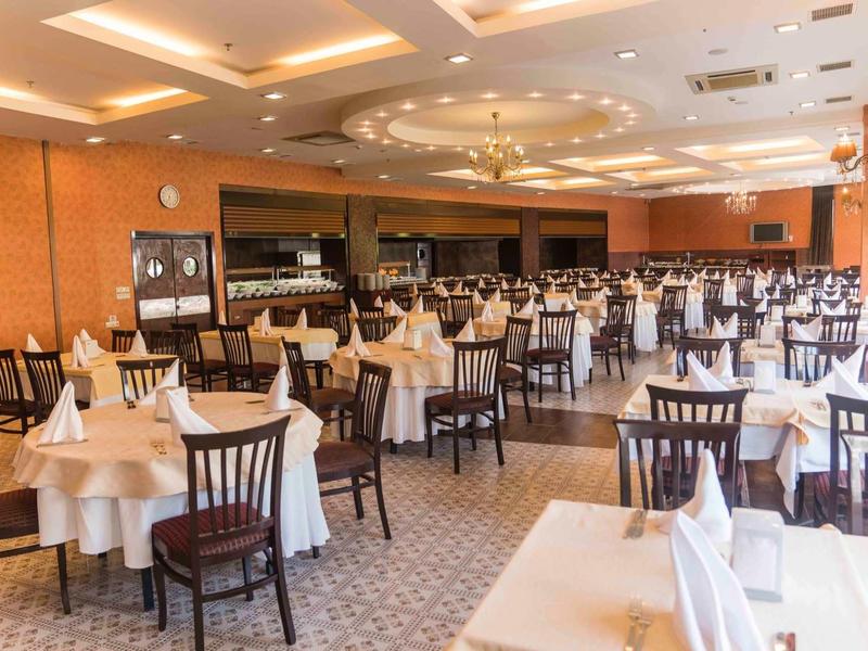 Velká jídelna s prostřenými stoly a židlemi v elegantní restauraci.