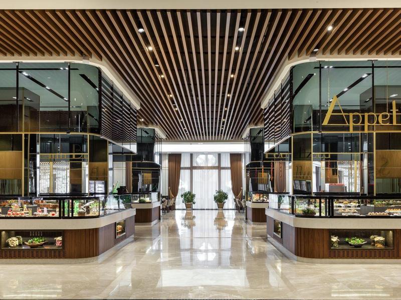 Lobby de hotel moderna con suelo de mármol brillante, techos altos y mostradores de recepción elegantes.