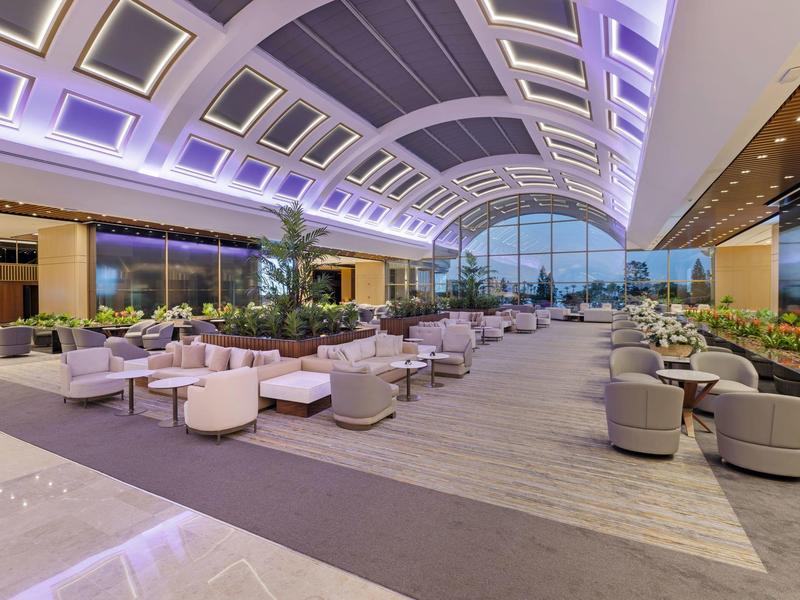 Amplia zona de estar moderna en hotel con sillones redondos y gran ventana de vidrio.