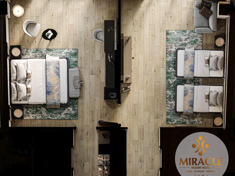 Vista aérea de una habitación de hotel moderna con dos dormitorios y piso de madera.