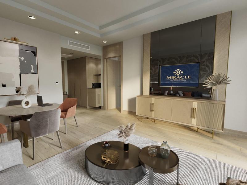 Área de estar moderna con televisor, mesas de centro y mesa de comedor en una habitación luminosa.