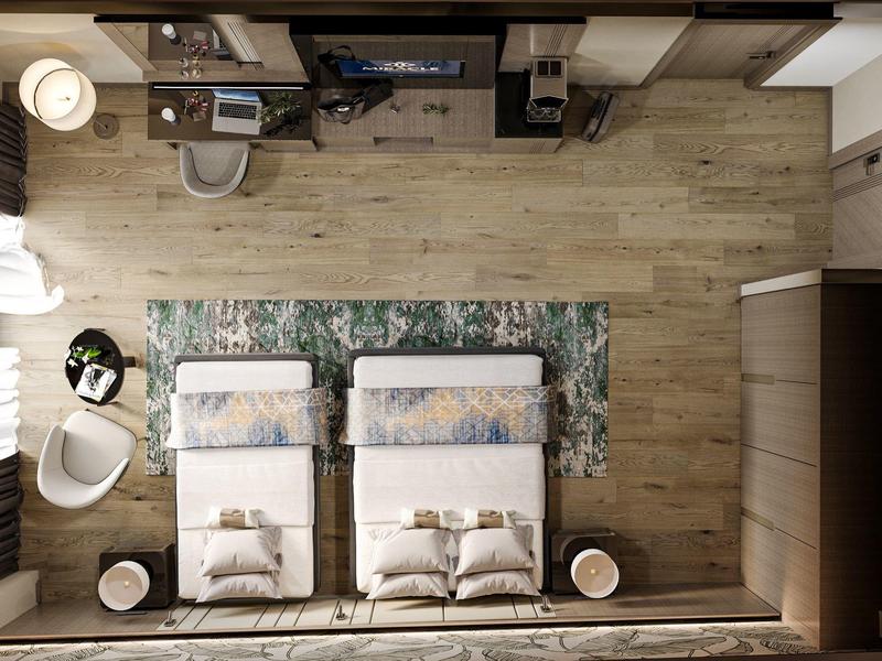 Habitación de hotel con dos camas individuales, alfombra, sillones y decoración moderna.