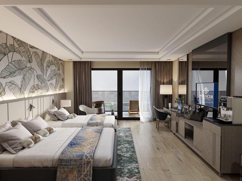 Habitación de hotel moderna con dos camas, balcón y vista al mar a la luz del día.