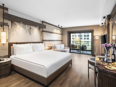 Modern hotel room with large bed, balcony, and decorative wall design.