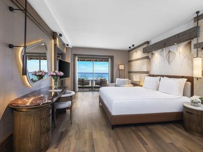 Modern hotel room with double bed, desk, and sea view