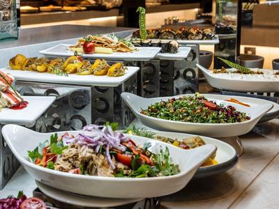 Various colorful salads served in white bowls on a buffet table at a restaurant.