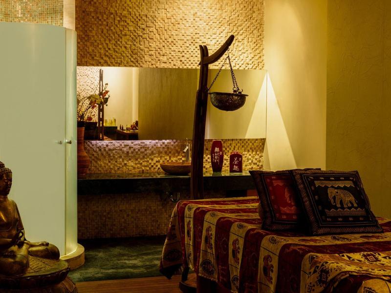 Cozy room with Asian-inspired decor and Buddha statue next to the bed.