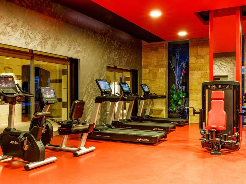 Hotel gym with treadmills, stationary bikes, and strength equipment.