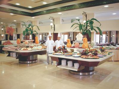 Grand buffet avec fruits exotiques et plats dans un restaurant d'hôtel moderne et lumineux.